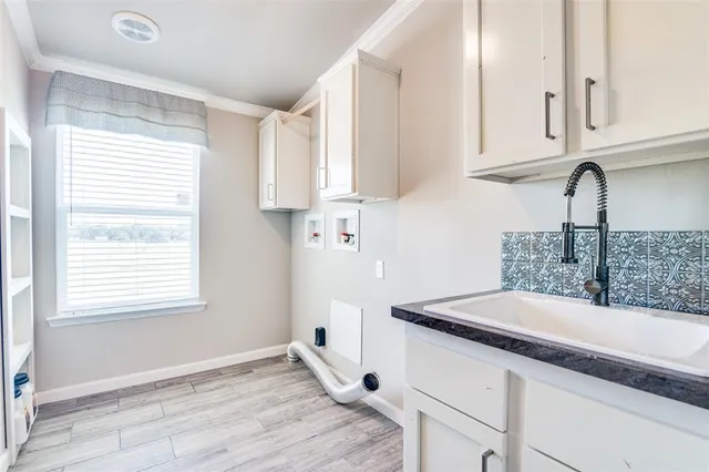 a kitchen with granite countertop white cabinets and a sink