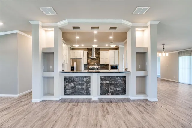 a open kitchen with a refrigerator and a stove top oven
