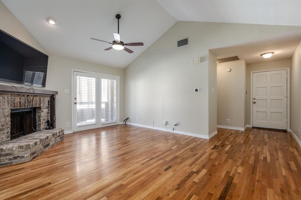 5200 Martel Avenue, Unit 37C Dallas, TX 75206 - Photo 2 of 26 a view of an empty room with wooden floor fireplace and a window