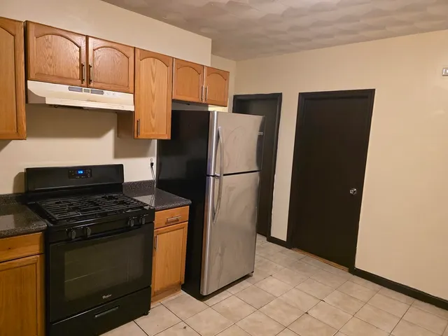 a kitchen with stainless steel appliances granite countertop a refrigerator and a stove