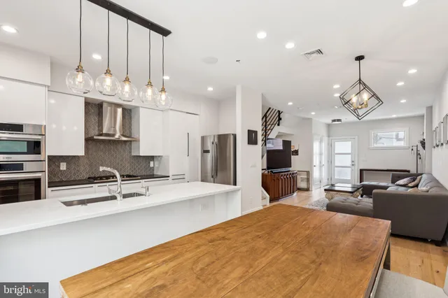 a kitchen with stainless steel appliances kitchen island granite countertop a sink and a refrigerator