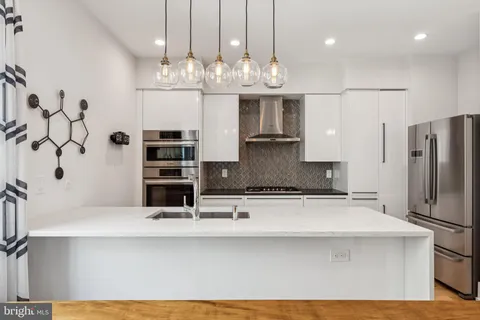 a kitchen with granite countertop a sink stainless steel appliances and cabinets