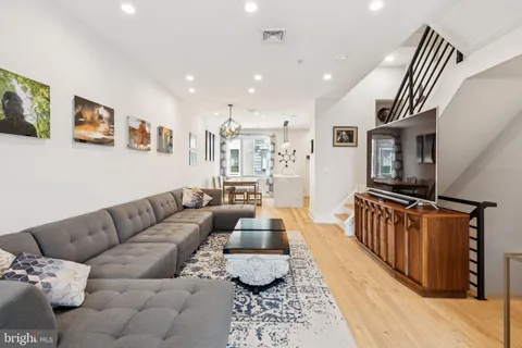 a living room with furniture and a wooden floor