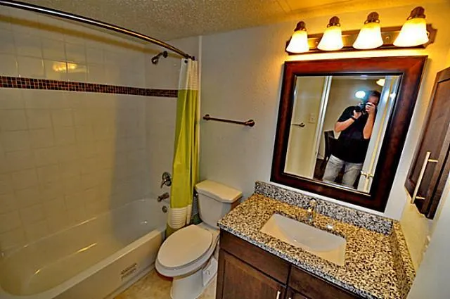 a bathroom with a granite countertop sink toilet and shower