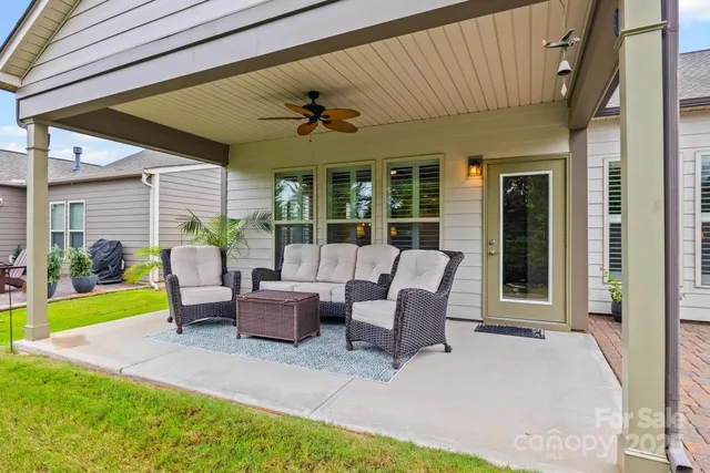 a view of a patio with couches chairs and a big yard