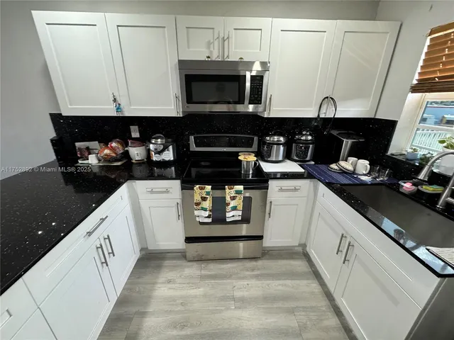 a kitchen with stainless steel appliances granite countertop a stove and a microwave