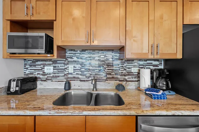 a kitchen with stainless steel appliances granite countertop a sink and a stove