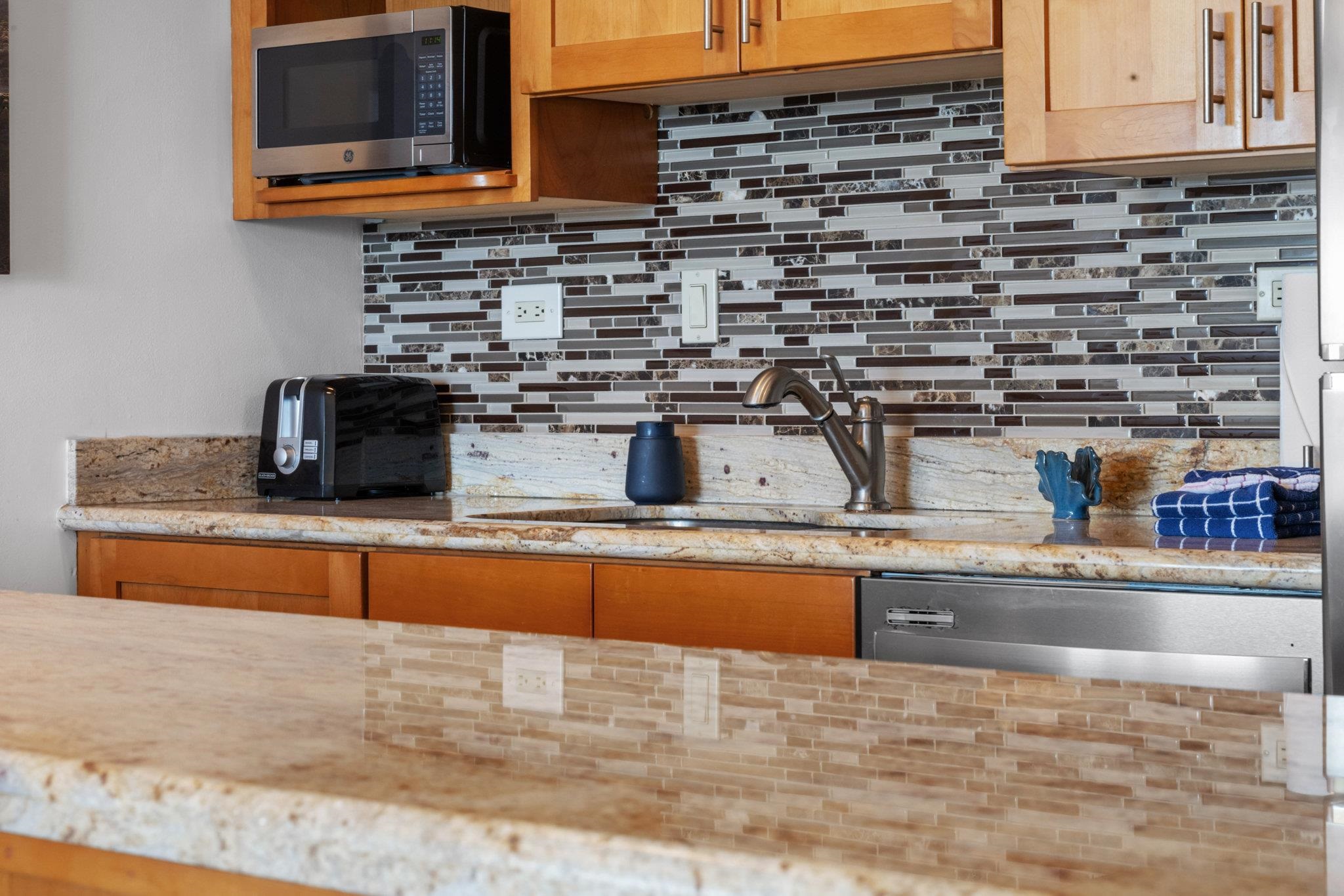 4471 Lower Honoapiilani Road, Unit 415 Lahaina, HI 96761 - Photo 20 of 44 a kitchen with stainless steel appliances granite countertop a sink and a stove