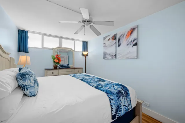 a bedroom with a bed and a lamp on dresser