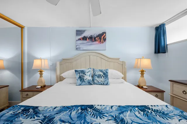 a bedroom with a bed and a mirror on dresser