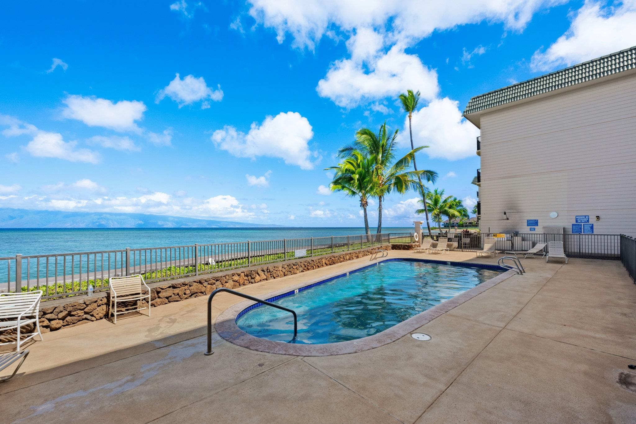 4471 Lower Honoapiilani Road, Unit 415 Lahaina, HI 96761 - Photo 36 of 44 a view of a swimming pool with a lounge chair