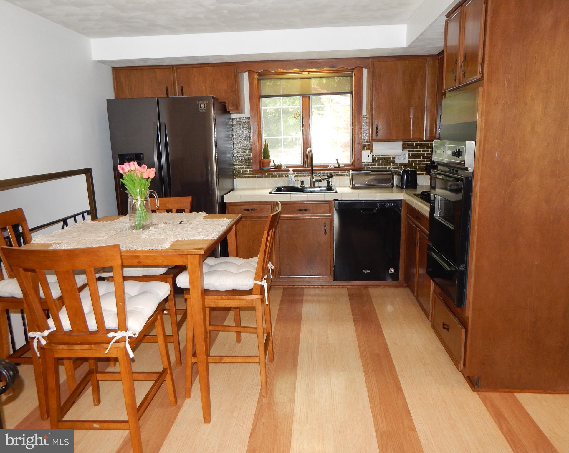 9716 Wynmill Road Philadelphia, PA 19115 - Photo 8 of 23 a kitchen with a table chairs and a refrigerator