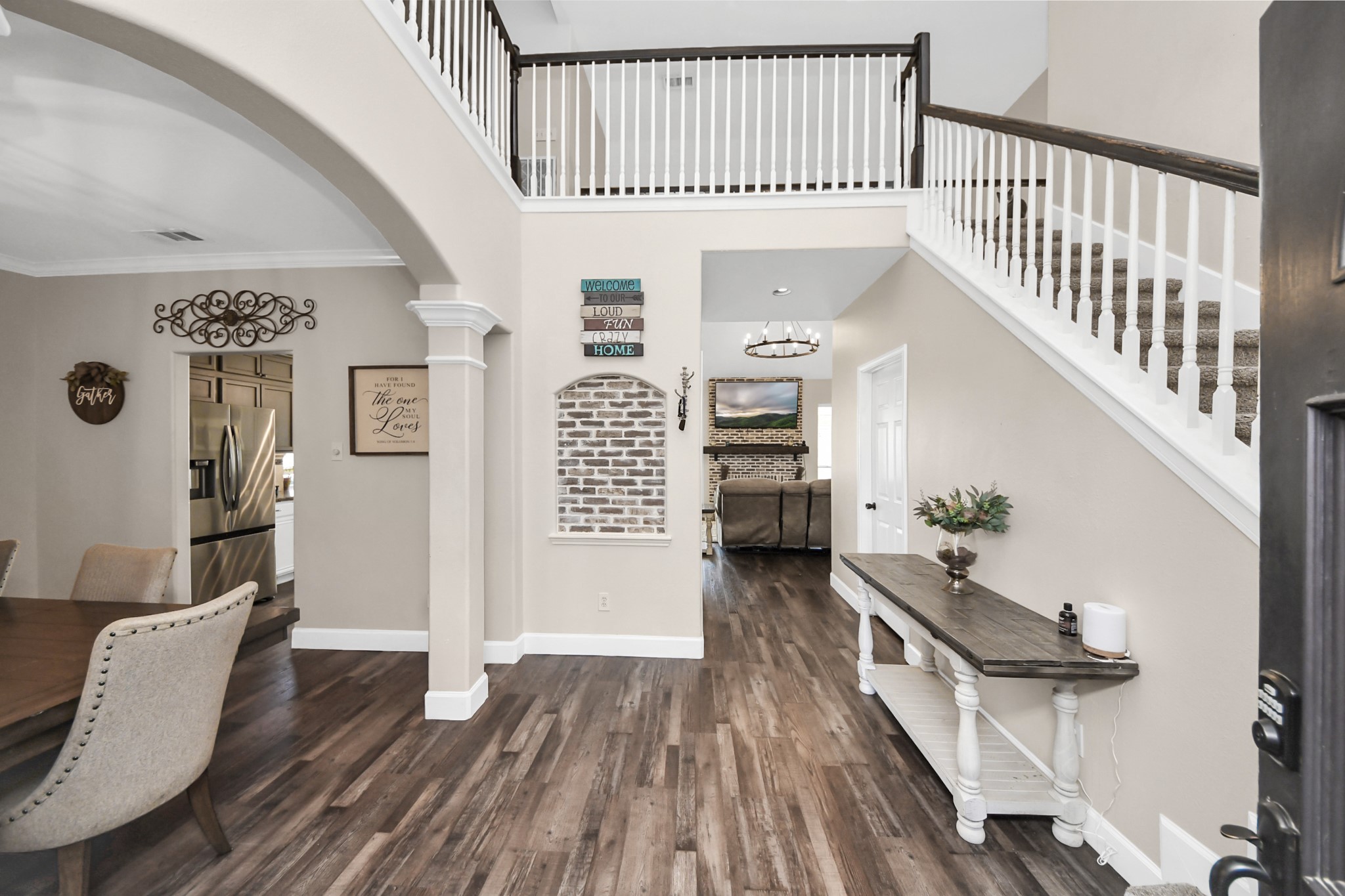 10514 Ravens Way Baytown, TX 77523 - Photo 26 of 50 View from the front entry into the living room, with the dining area visible to the left, highlighting the open flow of the main level.