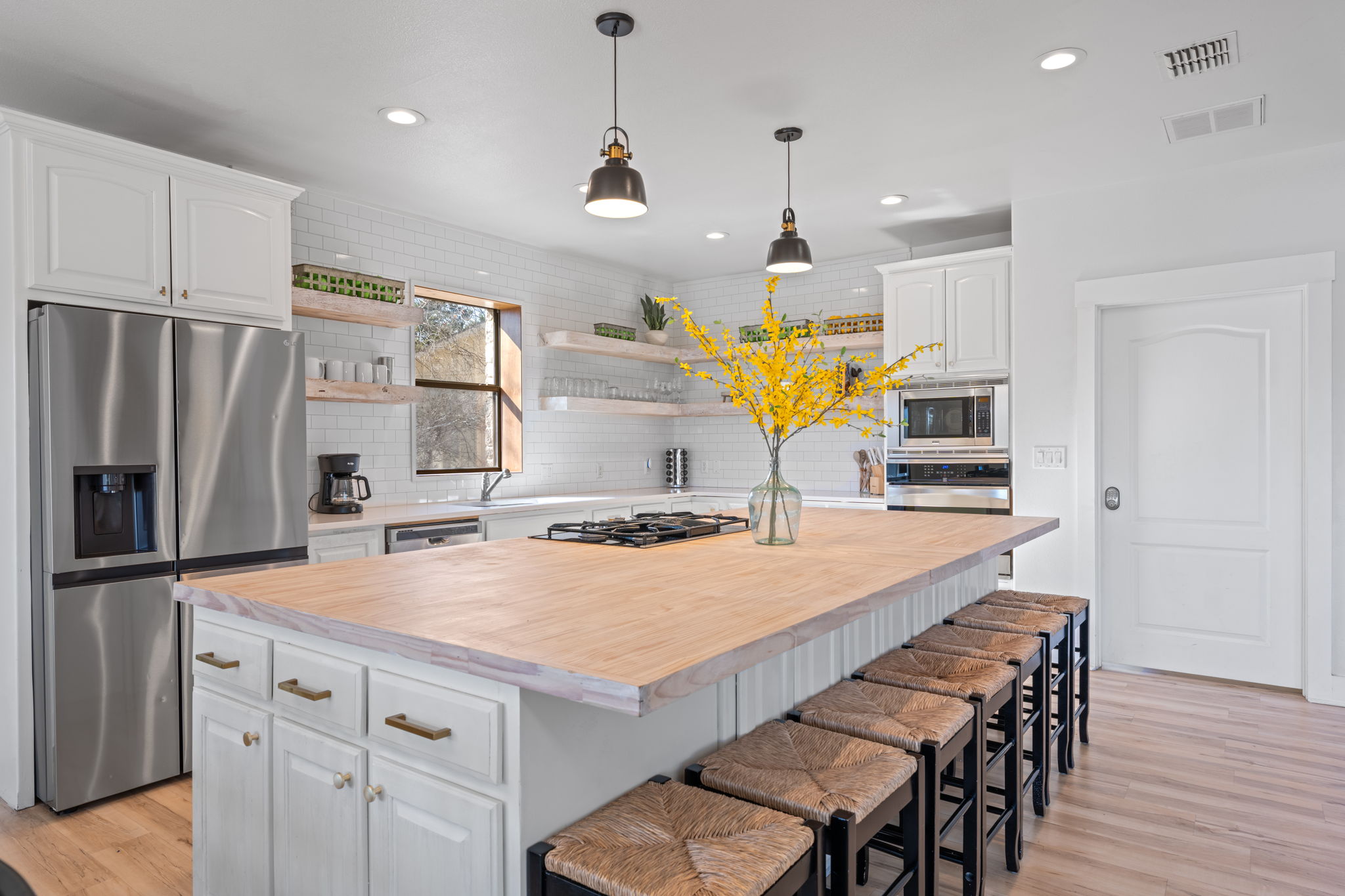 117 Point Road Fredericksburg, TX 78624 - Photo 11 of 40 Kitchen featuring butcher block countertops, a breakfast bar area, white cabinetry, stainless steel appliances, and open shelves
