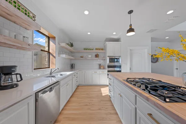 a large kitchen with stainless steel appliances granite countertop a stove and a sink