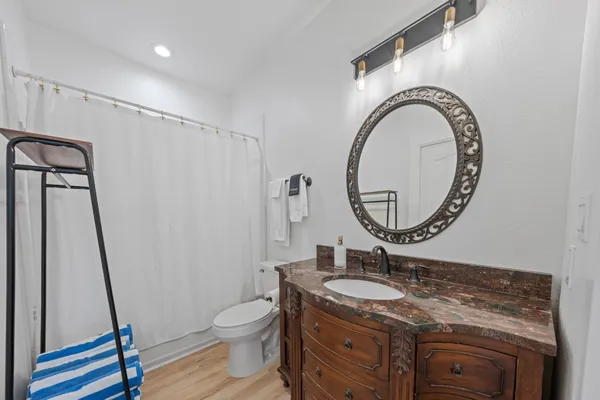 a bathroom with a granite countertop toilet sink and mirror
