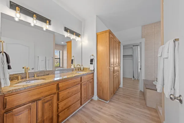 a bathroom with a double vanity sink mirror and shower