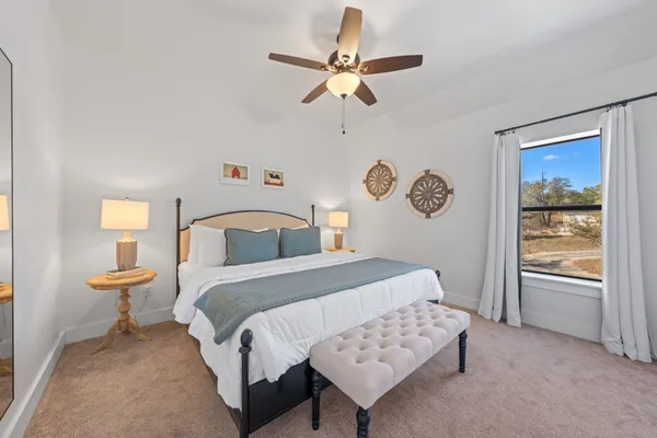 a bedroom with a bed and a lamp on dresser