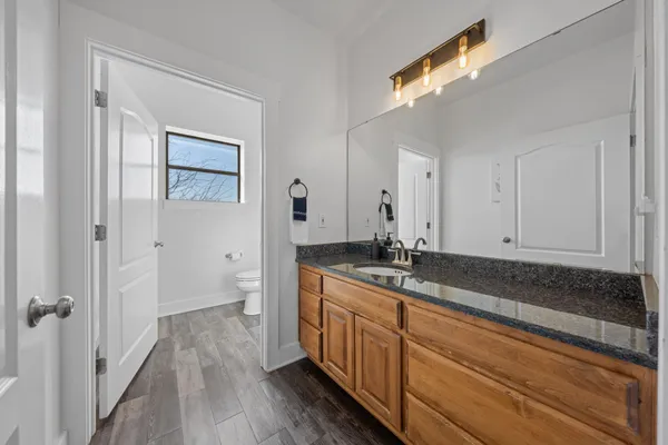 a bathroom with a granite countertop sink and a mirror
