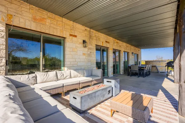 a view of a patio with couches chairs and wooden floor