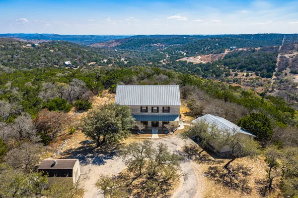 an aerial view of a house with a yard and lake view