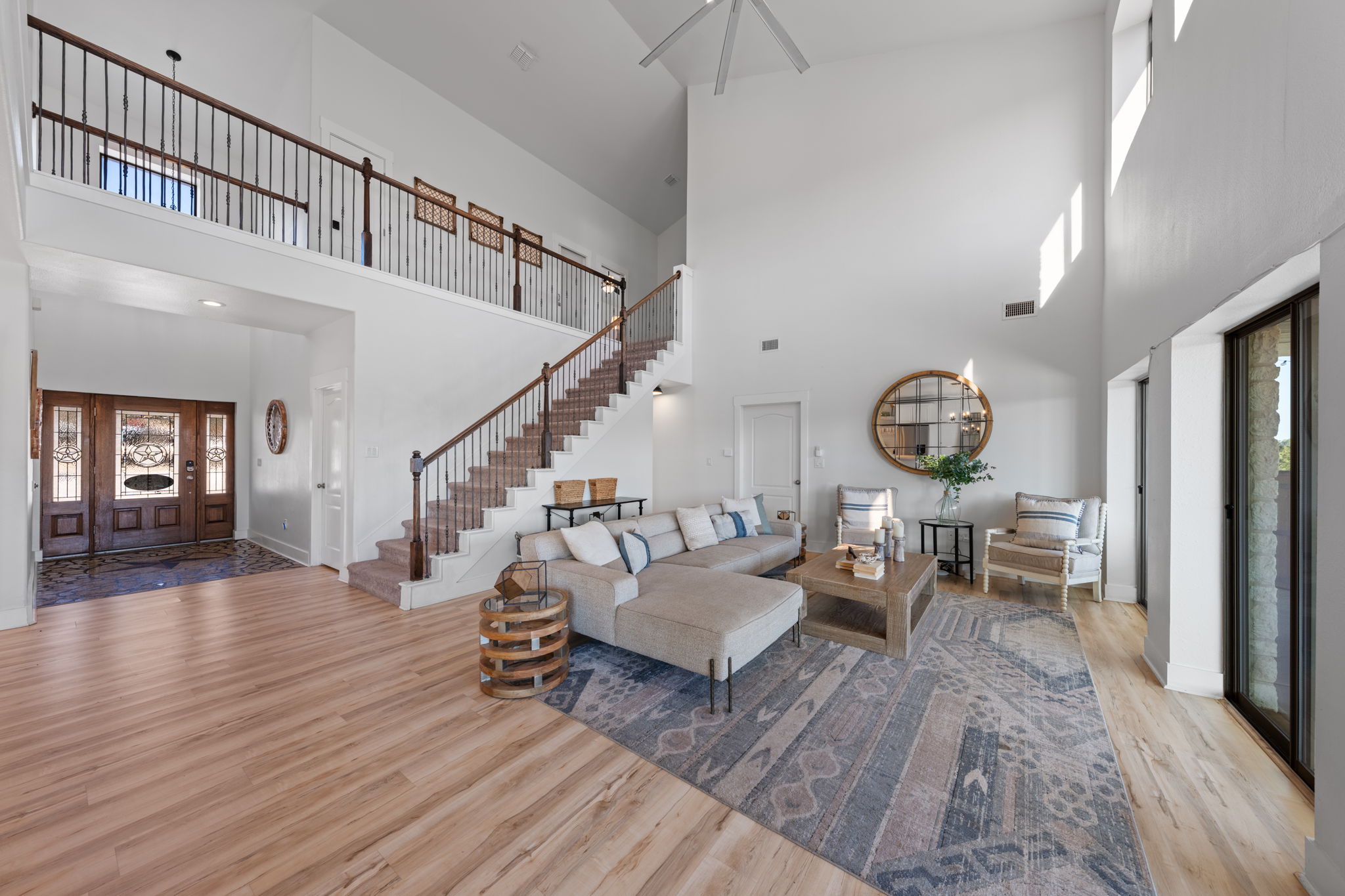 117 Point Road Fredericksburg, TX 78624 - Photo 7 of 40 Living room with light wood-style floors, healthy amount of natural light, and a high ceiling