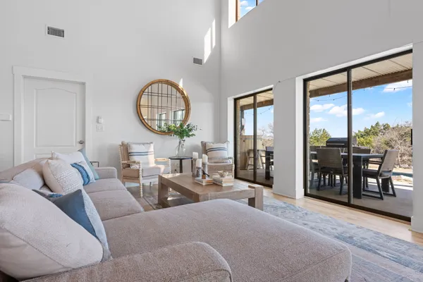 a living room with furniture a table and a large window