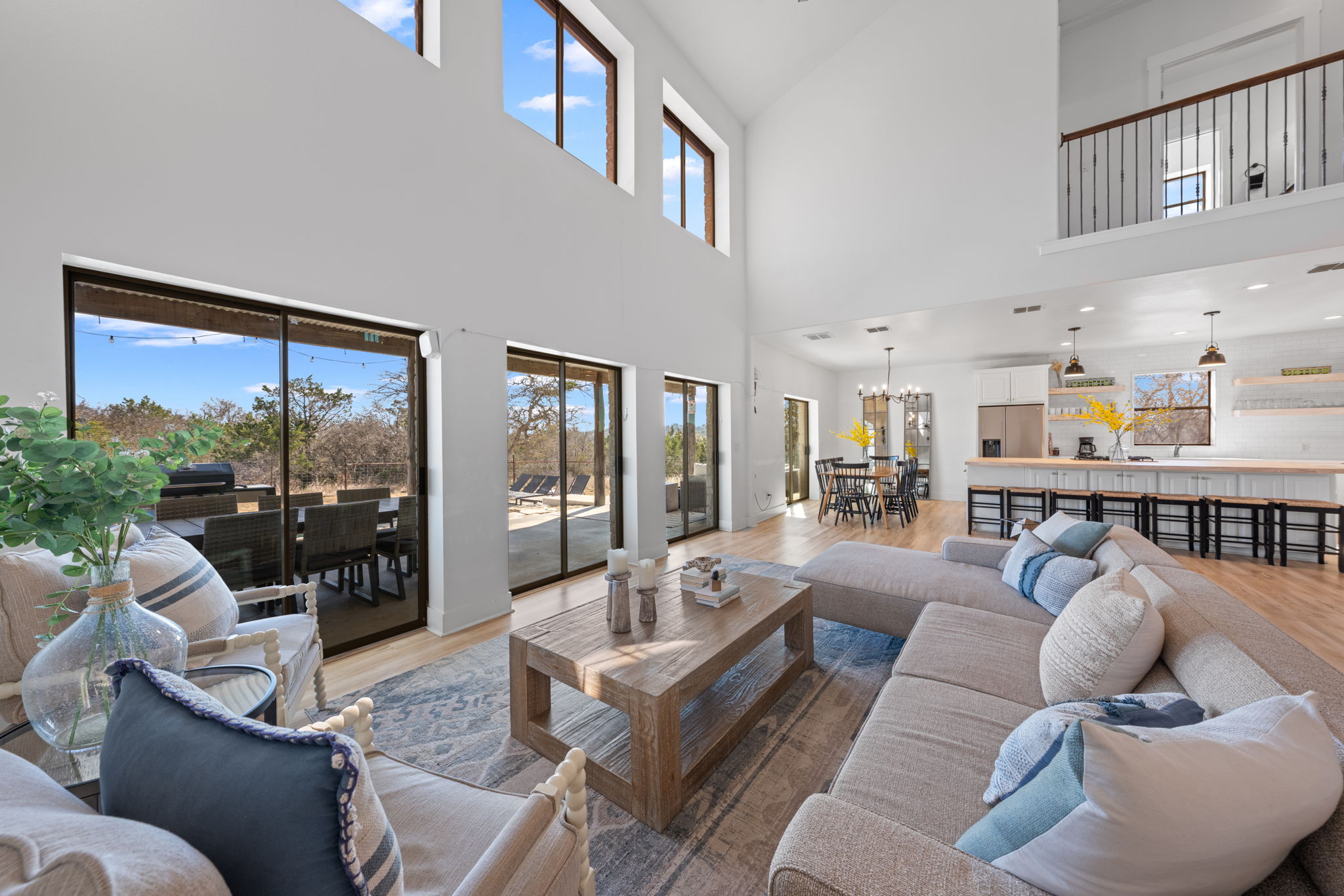 117 Point Road Fredericksburg, TX 78624 - Photo 9 of 40 Living area featuring light wood-style flooring, healthy amount of natural light, hanging lights, and lofted ceiling