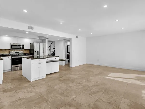 a kitchen that has a sink and a stove with granite countertop