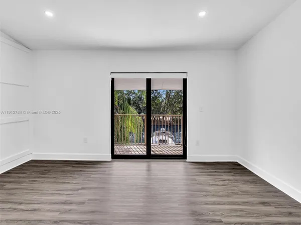 a view of a room that has wooden floor and a window