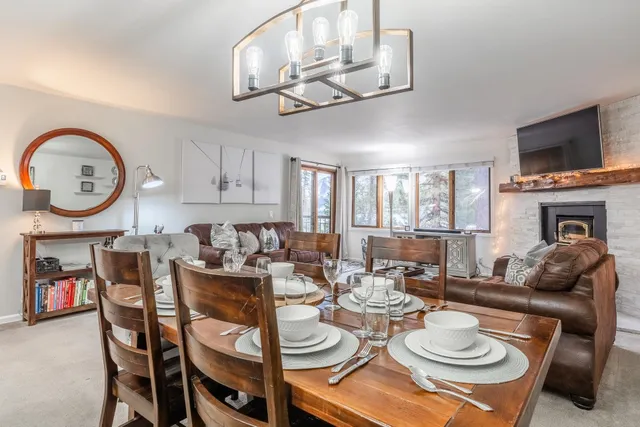 a living room with furniture a flat screen tv and kitchen view
