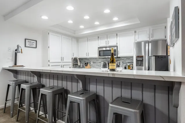 a kitchen with kitchen island white cabinets and stainless steel appliances