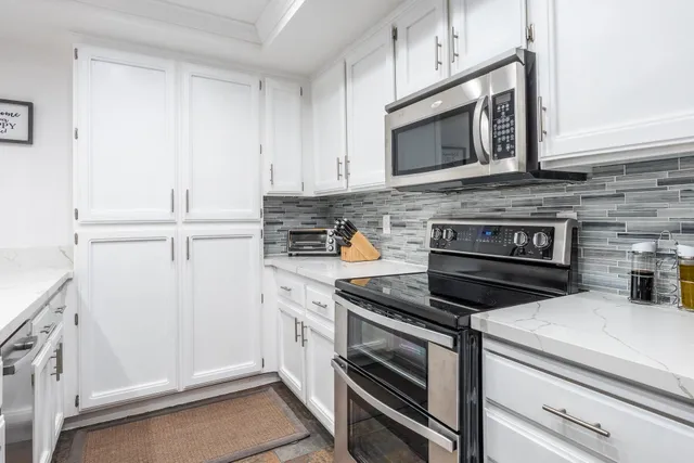a kitchen with microwave cabinets and stove top oven