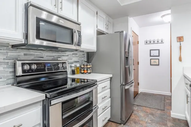 a kitchen with stainless steel appliances a stove microwave and refrigerator