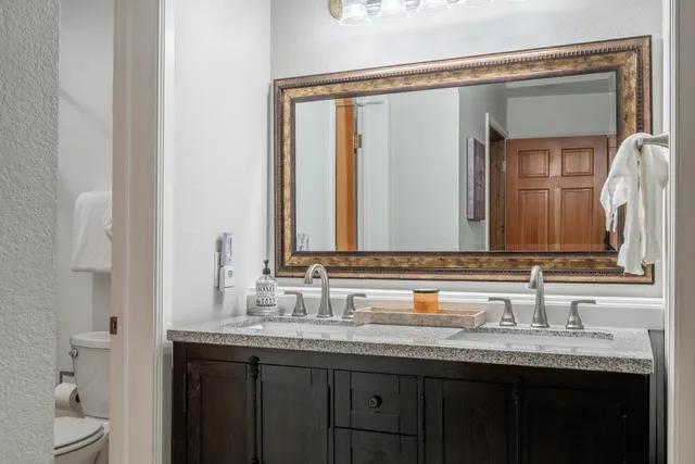 a bathroom with a granite countertop sink toilet and shower