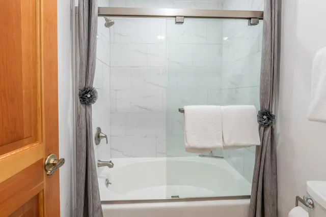 a bedroom with a bed and a flat tv screen on wall