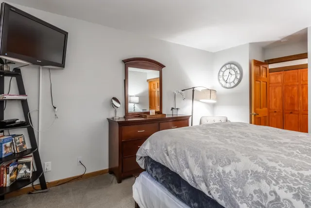 a bedroom with a bed and a dresser with mirror