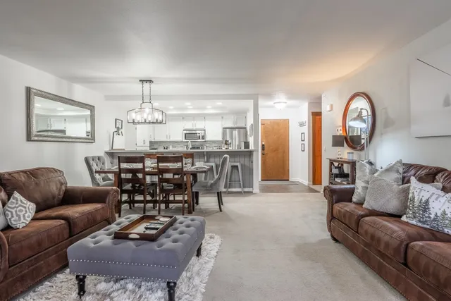 a living room with furniture a dining table and a chandelier