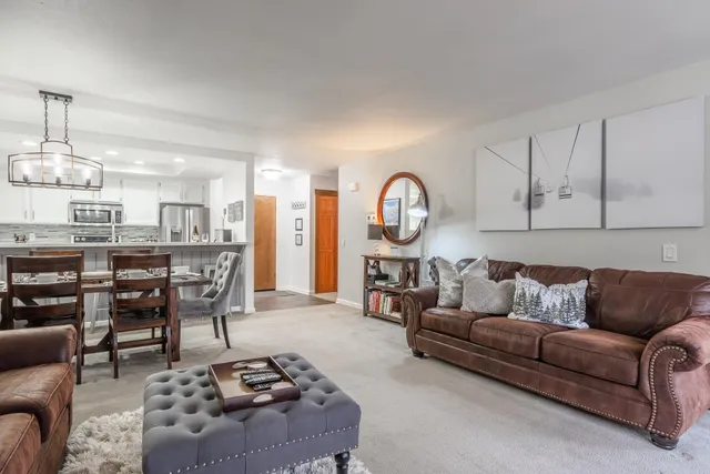 a living room with furniture a rug and kitchen view
