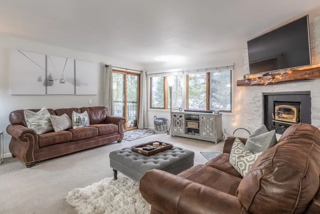 a living room with furniture large window and a flat screen tv