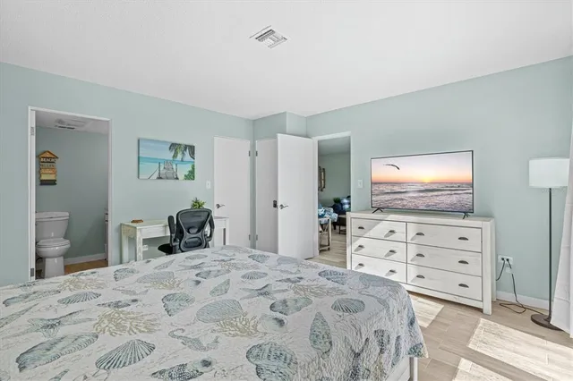 a bedroom with a bed and a flat screen tv in it