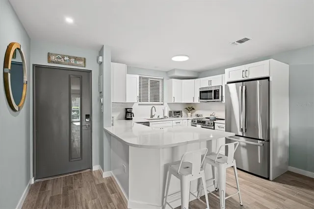 a kitchen with stainless steel appliances a refrigerator sink and stove