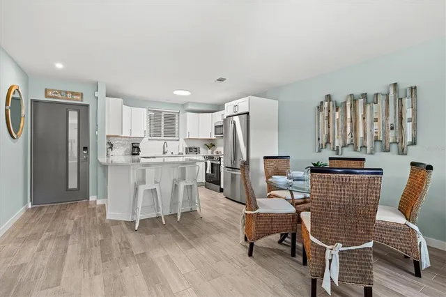 a living room with furniture a refrigerator and kitchen view