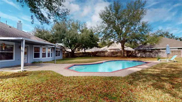 a view of a house with swimming pool and sitting area
