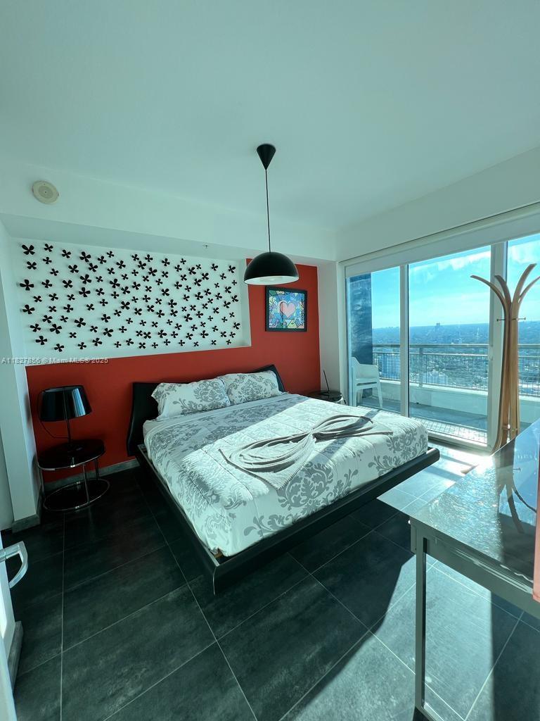 60 Southwest 13th Street, Unit 3407 Miami, FL 33130 - Photo 6 of 24 a bedroom with a bed and a window