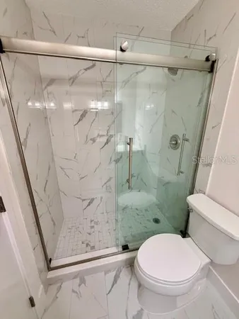 a bathroom with a toilet and a shower