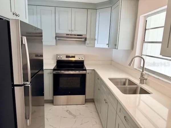 a kitchen with a refrigerator sink and cabinets