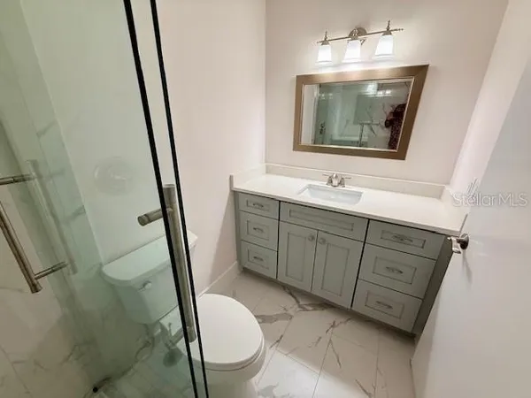 a bathroom with 2 sink toilet and a mirror