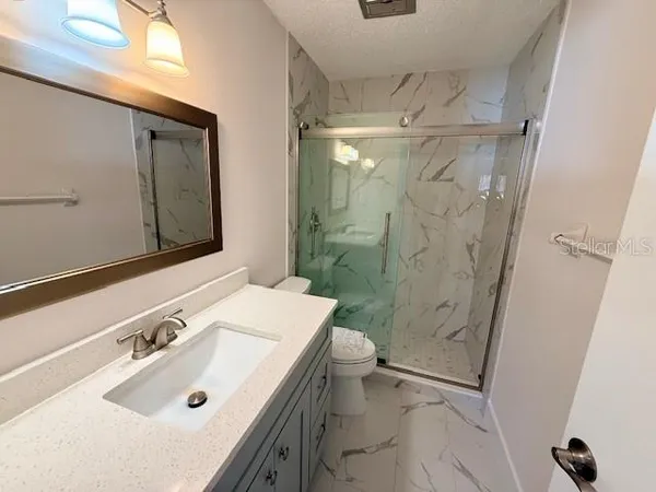a bathroom with a sink a toilet and shower