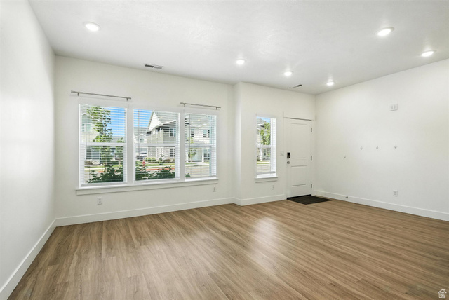 1221 West 1870 South Logan, UT 84321 - Photo 3 of 20 Spacious room featuring wood-finish flooring, recessed lighting, and multiple windows with blinds